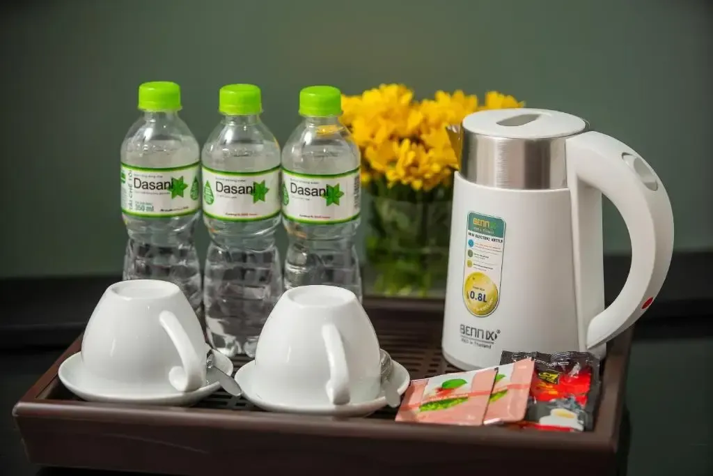 In-room hospitality tray with complimentary bottled water, electric kettle, and tea