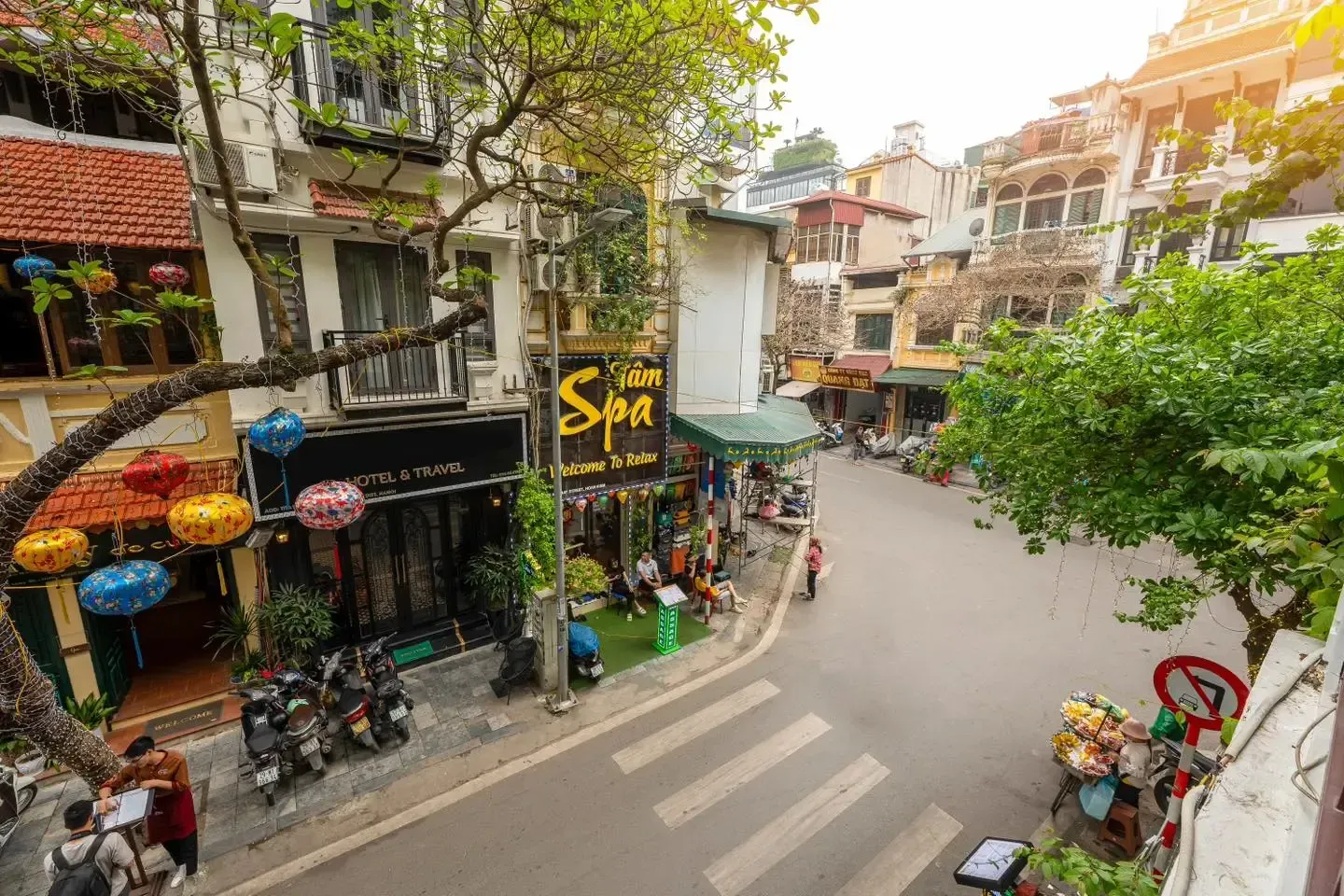 Elevated street view of Ma May Street corner with green trees and local shops