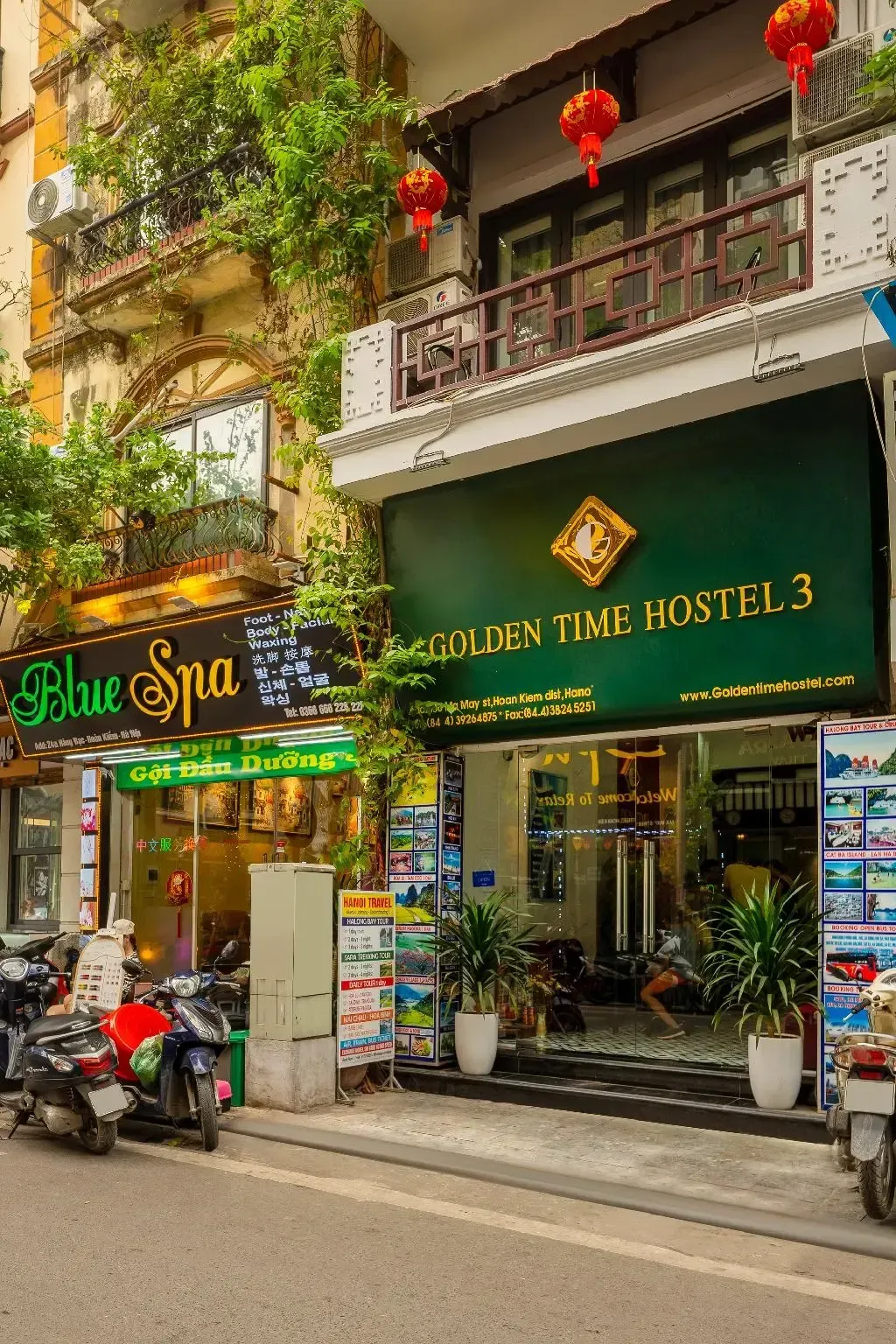 Close-up of the green Golden Time Hostel 3 sign and hanging red lanterns